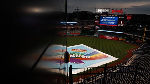 A screen directs fans to take cover under the concourse as a storm approaches and a tarp covers the field during a rain delay of a baseball game between the San Francisco Giants and the Washington Nationals Friday Aug. 11 2017 in Washington. (AP
