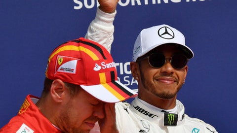 Mercedes driver Lewis Hamilton of Britain right stands on the podium with Ferrari driver Sebastian Vettel of Germany after the qualifying session ahead of the Belgian Formula One Grand Prix in Spa-Francorchamps Belgium Saturday Aug. 26 2017. Lewis H