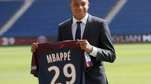 6 2017 French soccer player Kylian Mbappe poses with his Paris Saint Germain team shirt following a press conference in Paris. The elite teams enter the Champions League competition this week when the