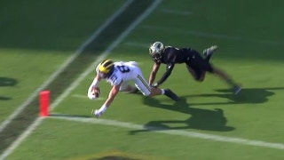 Michigan's John O'Korn connects for a 12-yd touchdown pass against Purdue