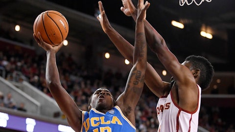 UCLA guard Kris Wilkes left shoots as Southern California forward Chimezie Metu defends during the first half of an NCAA college basketball game Saturday