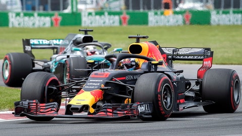 Red Bull Racing driver Daniel Ricciardo of Australia takes a turn at the Senna corner ahead of Mercedes driver Lewis Hamilton of Britain during the Formula One Canadian Grand Prix auto race in Montreal Sunday